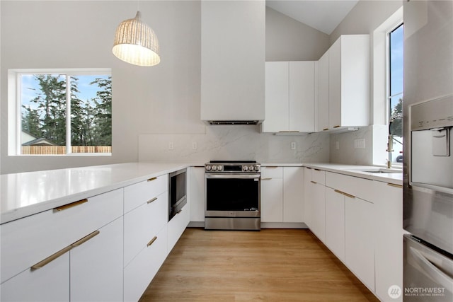 kitchen featuring a sink, backsplash, appliances with stainless steel finishes, and light countertops