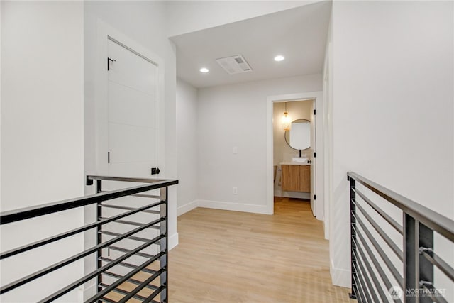 corridor featuring light wood-type flooring, an upstairs landing, visible vents, recessed lighting, and baseboards