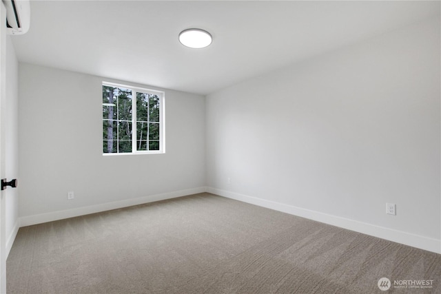 carpeted spare room featuring baseboards and a wall mounted AC