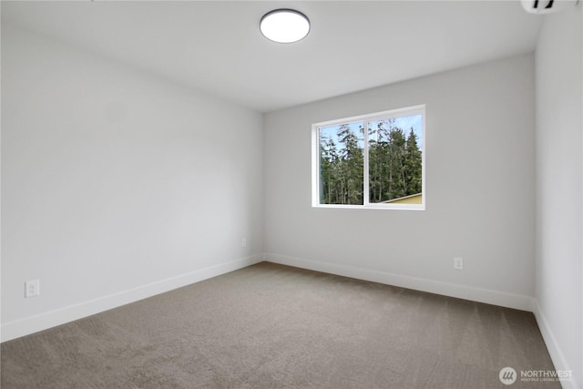 spare room featuring baseboards and carpet