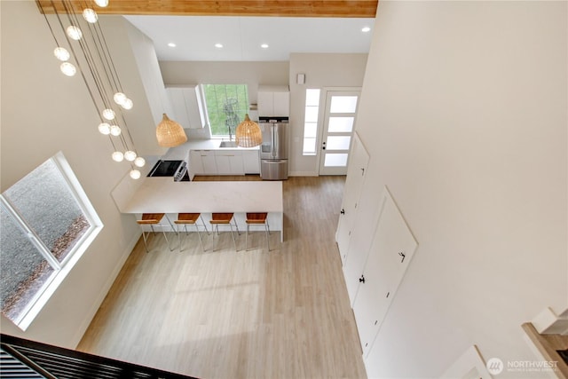 interior space featuring recessed lighting, light wood-type flooring, and baseboards