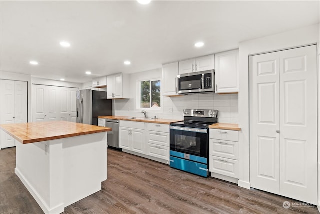 kitchen with white cabinetry, stainless steel appliances, and wooden counters