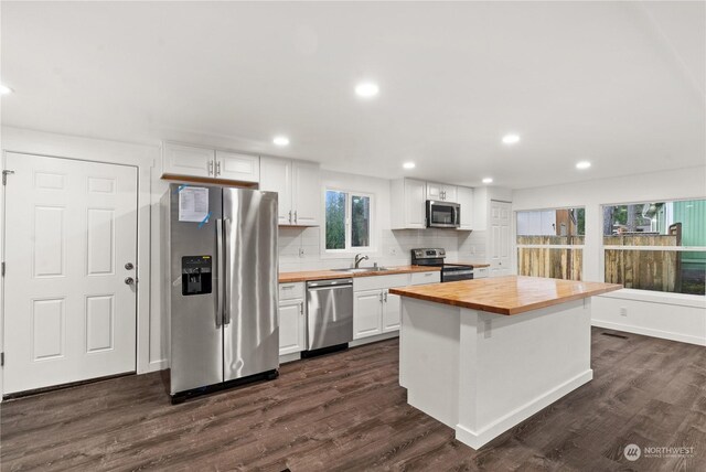 kitchen with butcher block counters, white cabinetry, dark hardwood / wood-style flooring, and appliances with stainless steel finishes