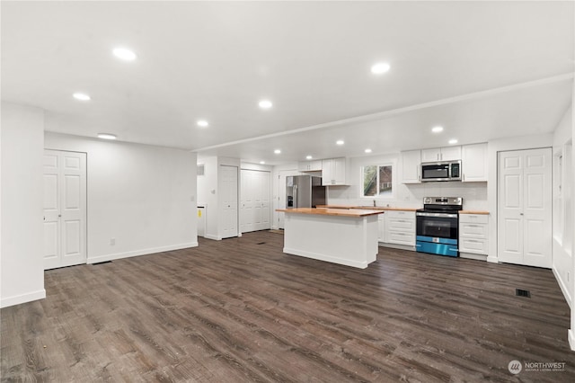 kitchen with wooden counters, appliances with stainless steel finishes, dark hardwood / wood-style flooring, and white cabinetry