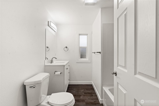 bathroom with toilet, vanity, a bath, and hardwood / wood-style flooring