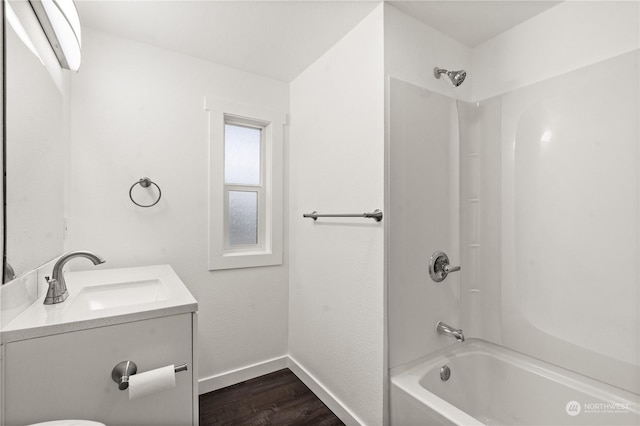 bathroom featuring hardwood / wood-style flooring, vanity, and shower / bathing tub combination