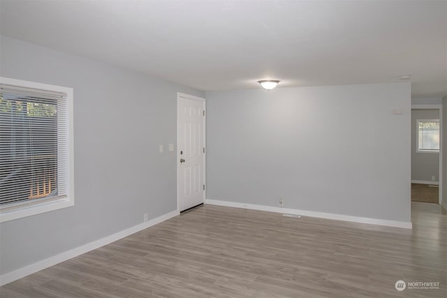 spare room featuring plenty of natural light and light hardwood / wood-style floors