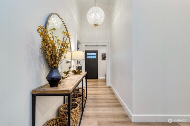 entryway featuring light hardwood / wood-style flooring and a chandelier