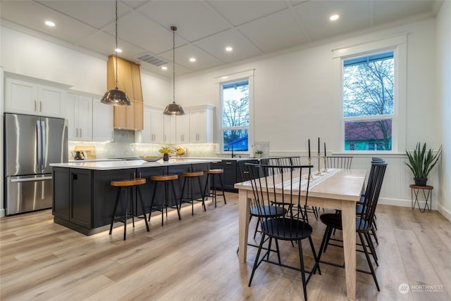 dining room with a towering ceiling and light hardwood / wood-style floors