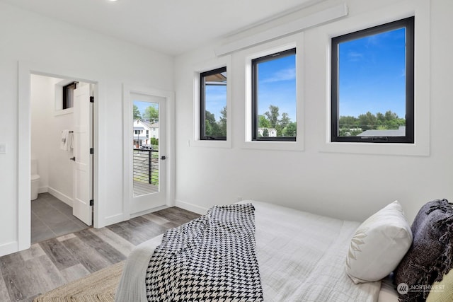 bedroom with light wood-type flooring and connected bathroom