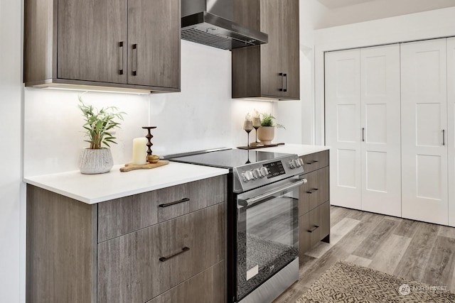 205 Riverwalk Dr, Lynden, WA 98264 - kitchen with wall chimney range hood, electric stove, light wood finished floors, light countertops, and modern cabinets