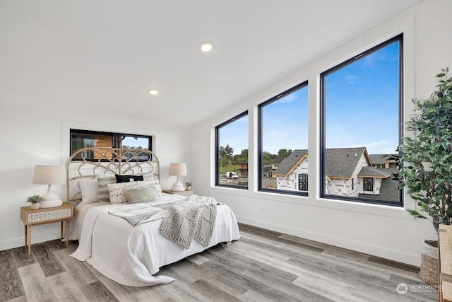 bedroom with wood-type flooring and multiple windows