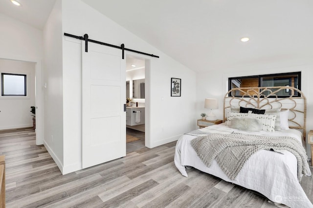 205 Riverwalk Dr, Lynden, WA 98264 - bedroom with a barn door, lofted ceiling, light wood-style flooring, recessed lighting, and connected bathroom