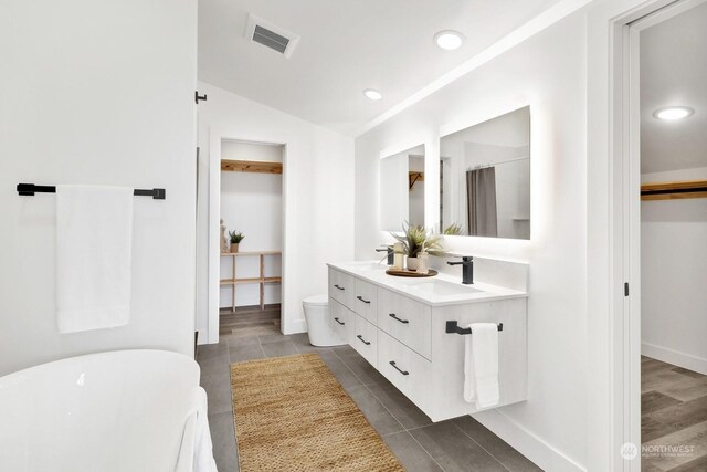 205 Riverwalk Dr, Lynden, WA 98264 - full bathroom with double vanity, a soaking tub, vaulted ceiling, a spacious closet, and tile patterned floors