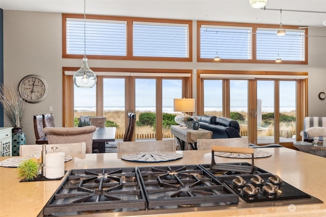 kitchen with a water view, hanging light fixtures, and french doors