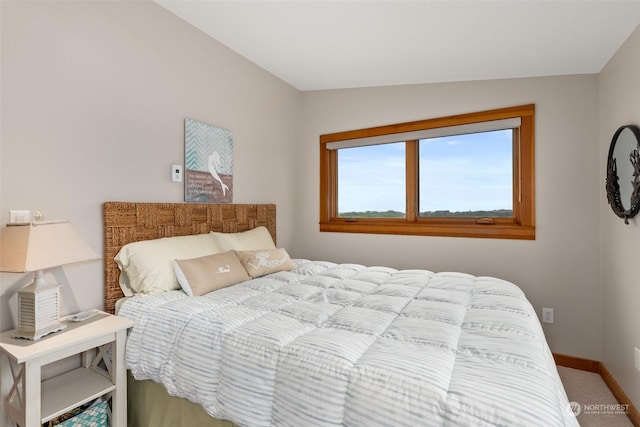 carpeted bedroom with lofted ceiling