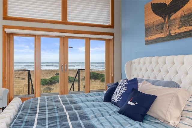 bedroom featuring a view of the beach, french doors, and a water view