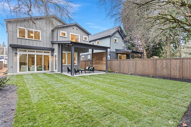 rear view of property featuring a lawn and a patio area