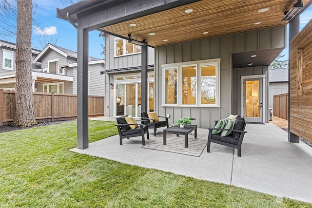 back of house with a lawn, an outdoor living space, and a patio