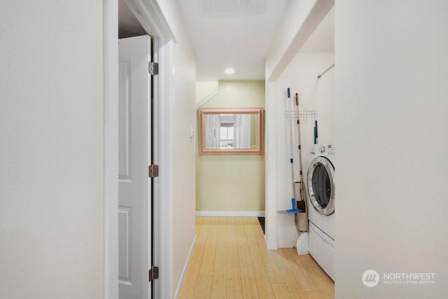 laundry room with light hardwood / wood-style floors and washer / dryer