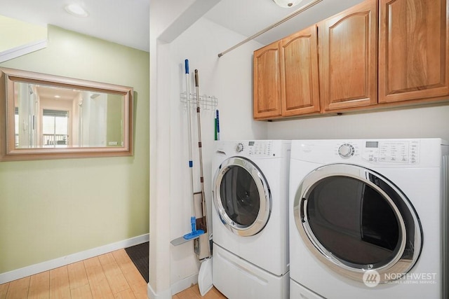 washroom featuring cabinets, light hardwood / wood-style floors, and washing machine and dryer