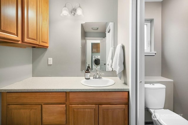 bathroom with vanity, washer / clothes dryer, and toilet