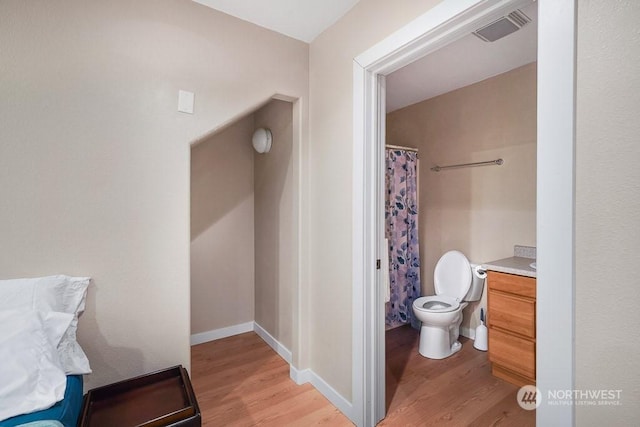 bathroom with toilet, vanity, and hardwood / wood-style flooring