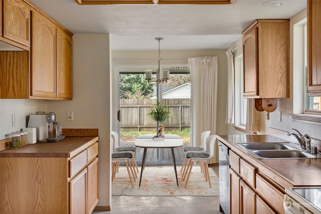 kitchen with a wealth of natural light, sink, hanging light fixtures, and an inviting chandelier