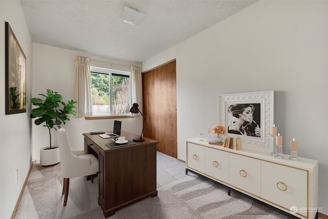 carpeted office with a textured ceiling