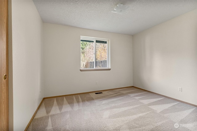 unfurnished room featuring carpet floors and a textured ceiling