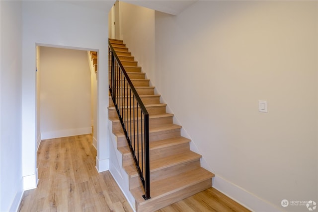 stairs featuring hardwood / wood-style flooring