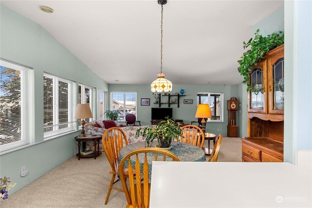 carpeted dining area with lofted ceiling