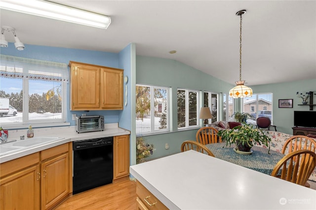 kitchen featuring lofted ceiling, sink, light hardwood / wood-style flooring, dishwasher, and decorative light fixtures