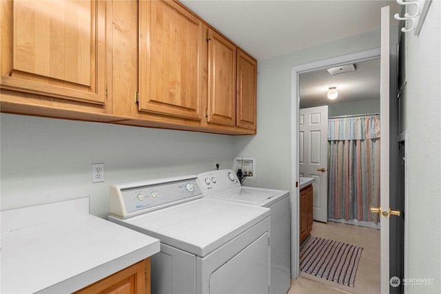 clothes washing area featuring separate washer and dryer and cabinets