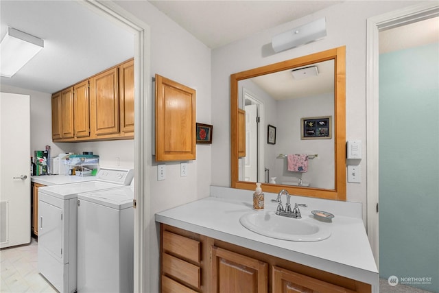 clothes washing area featuring sink, cabinets, and washer and dryer