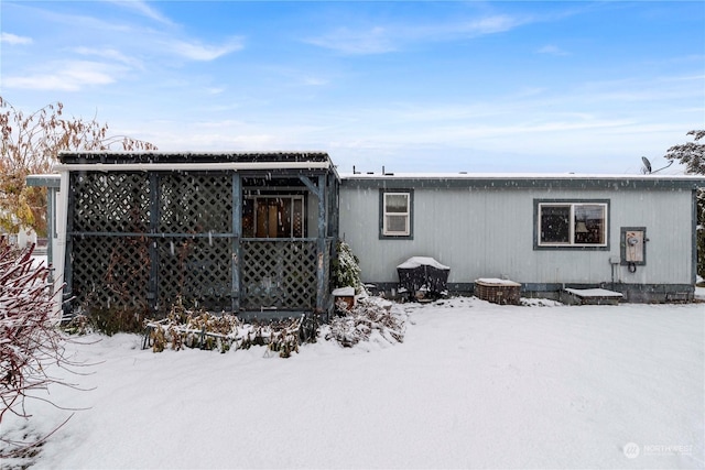 view of snow covered rear of property