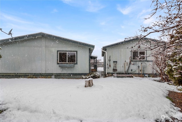 view of snow covered rear of property