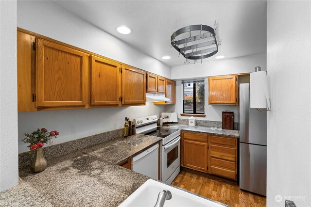 kitchen with white appliances, sink, and dark wood-type flooring