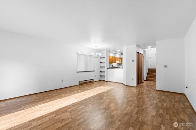 unfurnished living room featuring a baseboard radiator, a notable chandelier, and wood-type flooring