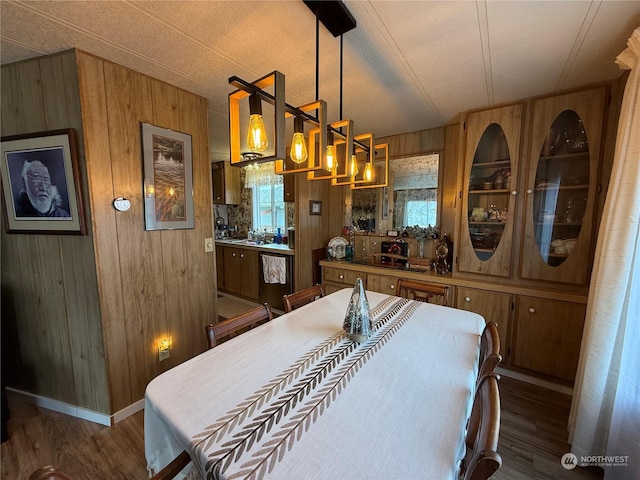 dining area featuring wood walls, dark hardwood / wood-style flooring, and a textured ceiling