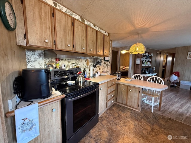 kitchen with decorative light fixtures, dark wood-type flooring, wooden walls, and black / electric stove