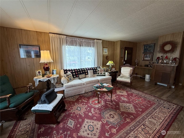 living room with hardwood / wood-style floors, a textured ceiling, and wood walls