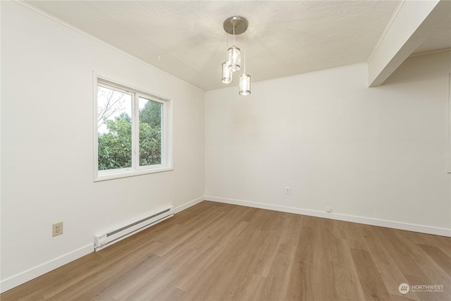 spare room with crown molding, hardwood / wood-style floors, and a baseboard radiator