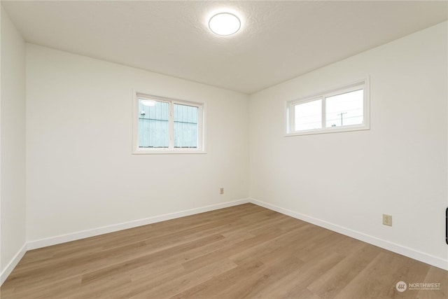 unfurnished room featuring light wood-type flooring and a textured ceiling