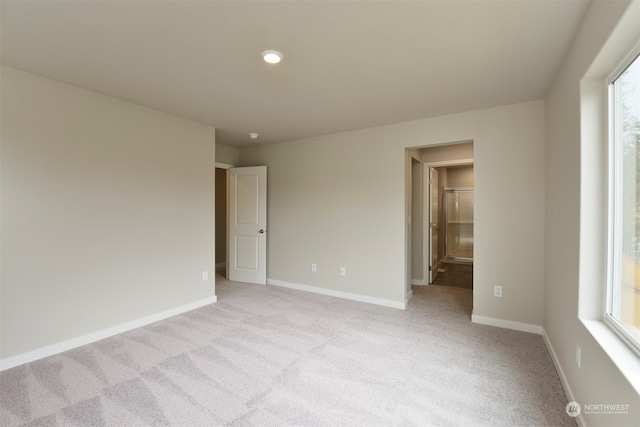 spare room with light colored carpet and a healthy amount of sunlight