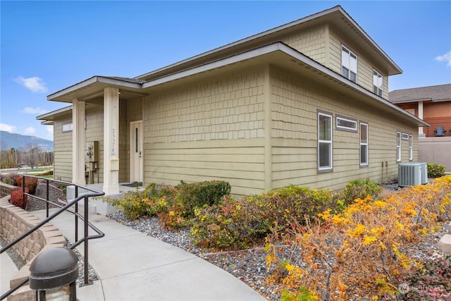 view of side of property featuring a mountain view and central AC unit