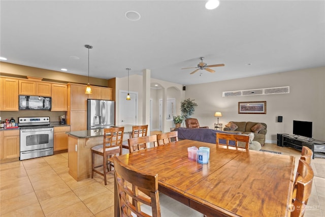 tiled dining space featuring ceiling fan