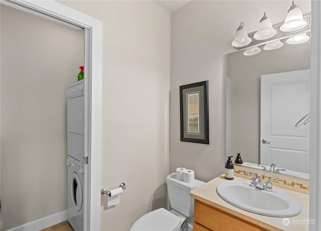 bathroom with vanity, toilet, and stacked washer / drying machine