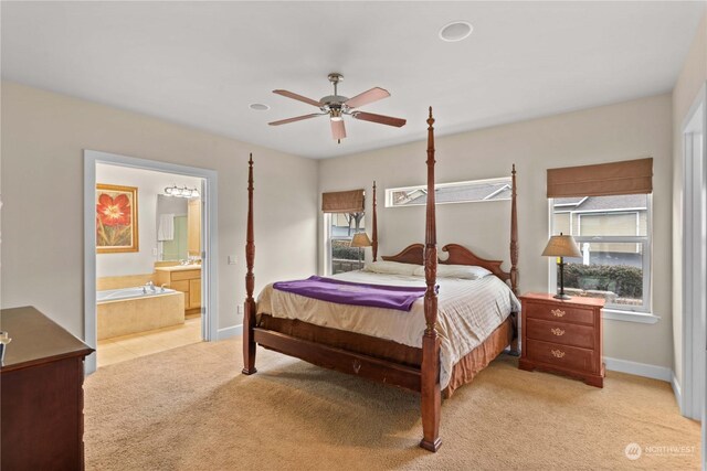 bedroom with ensuite bath, ceiling fan, and light colored carpet