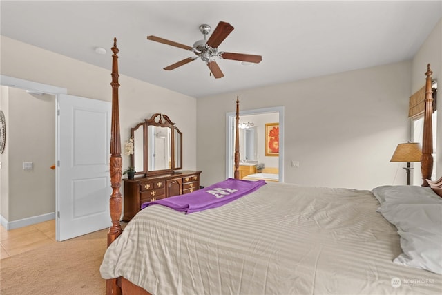 bedroom featuring light carpet, ensuite bathroom, and ceiling fan